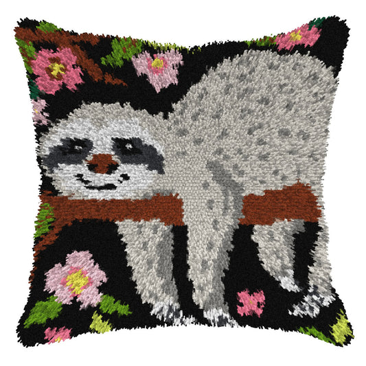 Finished Orchidea latch hook cushion showing a grey sloth on a branch against a black background with pink blossom