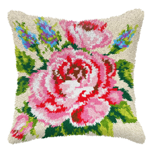 Finished Orchidea latch hook cushion showing a pink rose with green leaves and blue flowers on a cream background