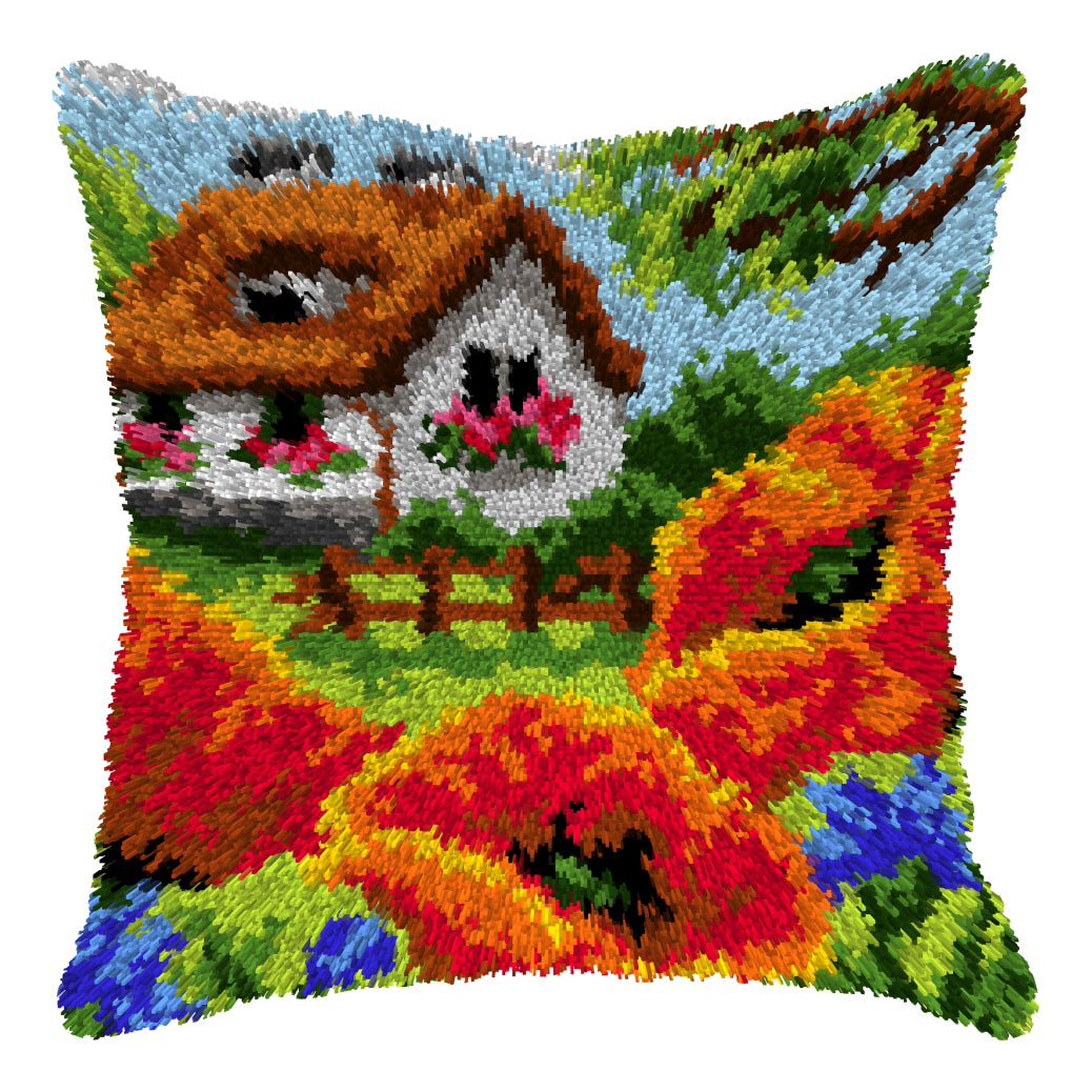 Finished Orchidea latch hook cushion showing a cottage with red poppies