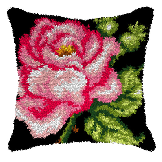 Finished Orchidea latch hook cushion showing a large pink rose with green leaves on a black background