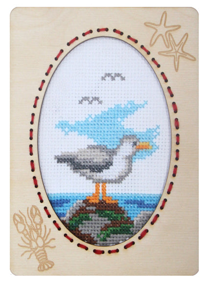 Orchidea cross stitch kit with a seagull design in an engraved wooden frame