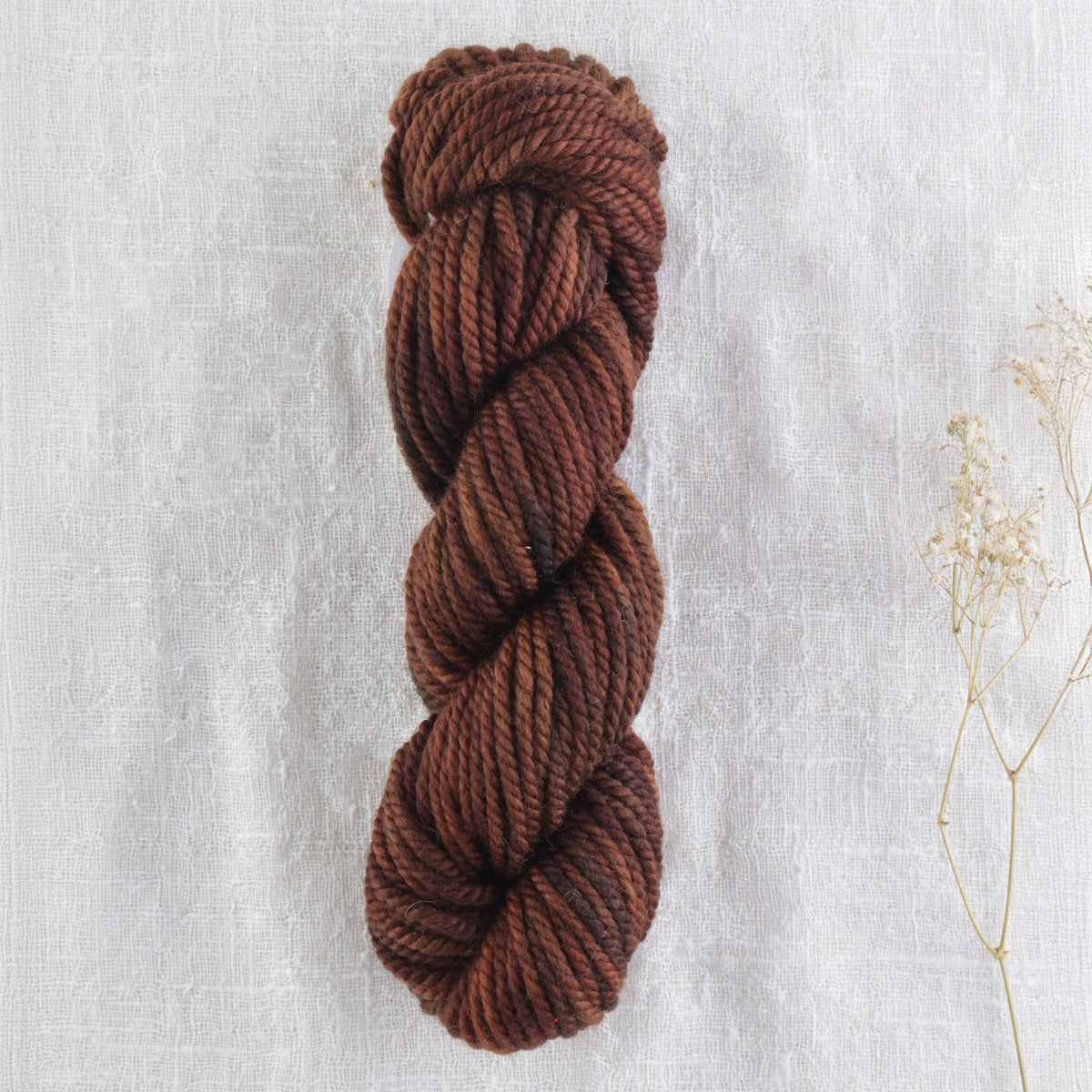 Skein of variegated Dark Roast rug weight punch needle wool yarn