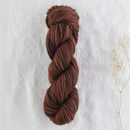 Skein of variegated Dark Roast rug weight punch needle wool yarn