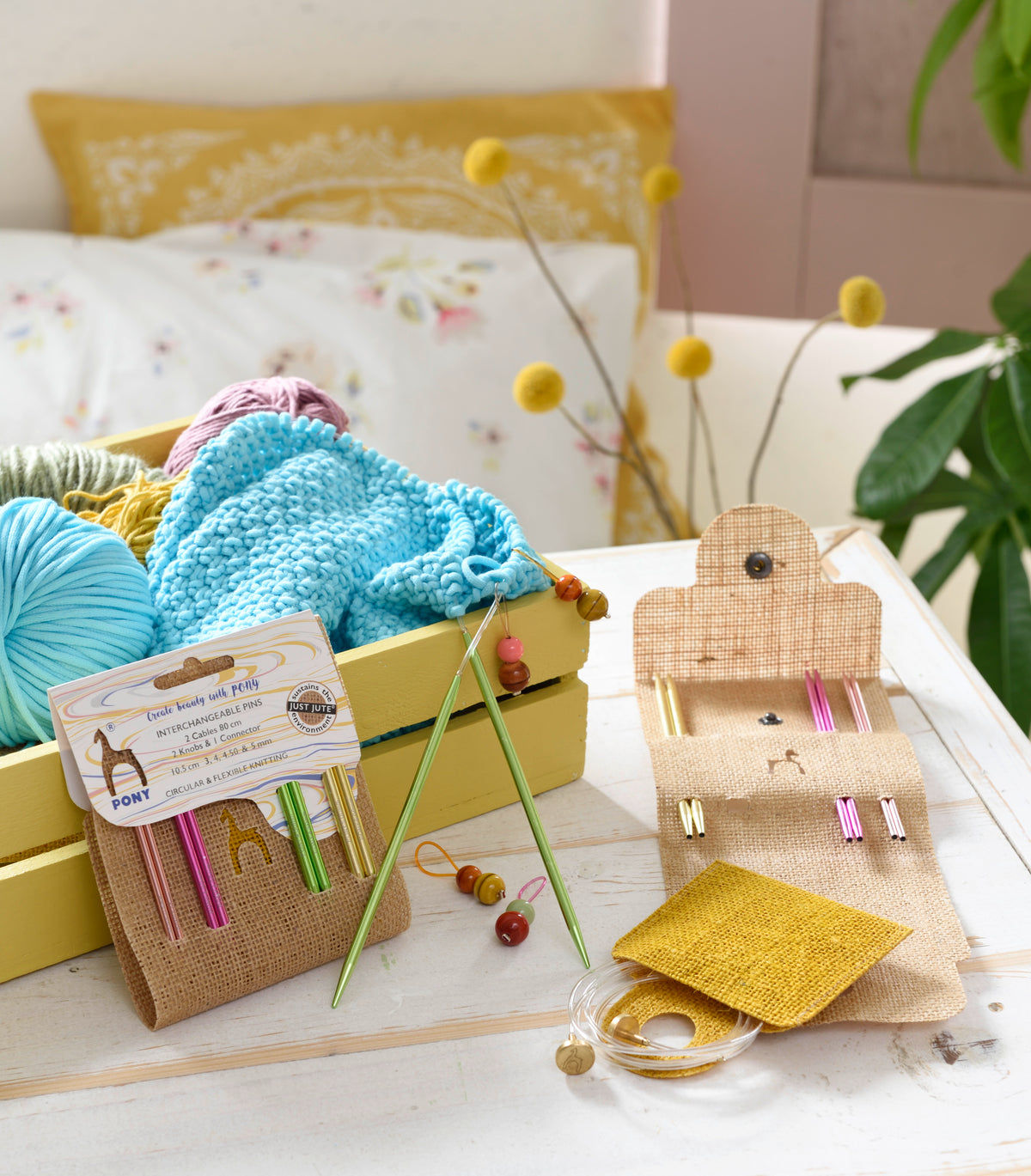Jute case holding colourful interchangeable circular knitting needles and cables