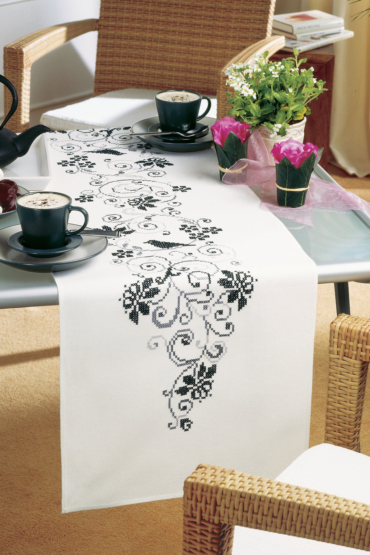 White cotton table runner stitched with a blackwork design