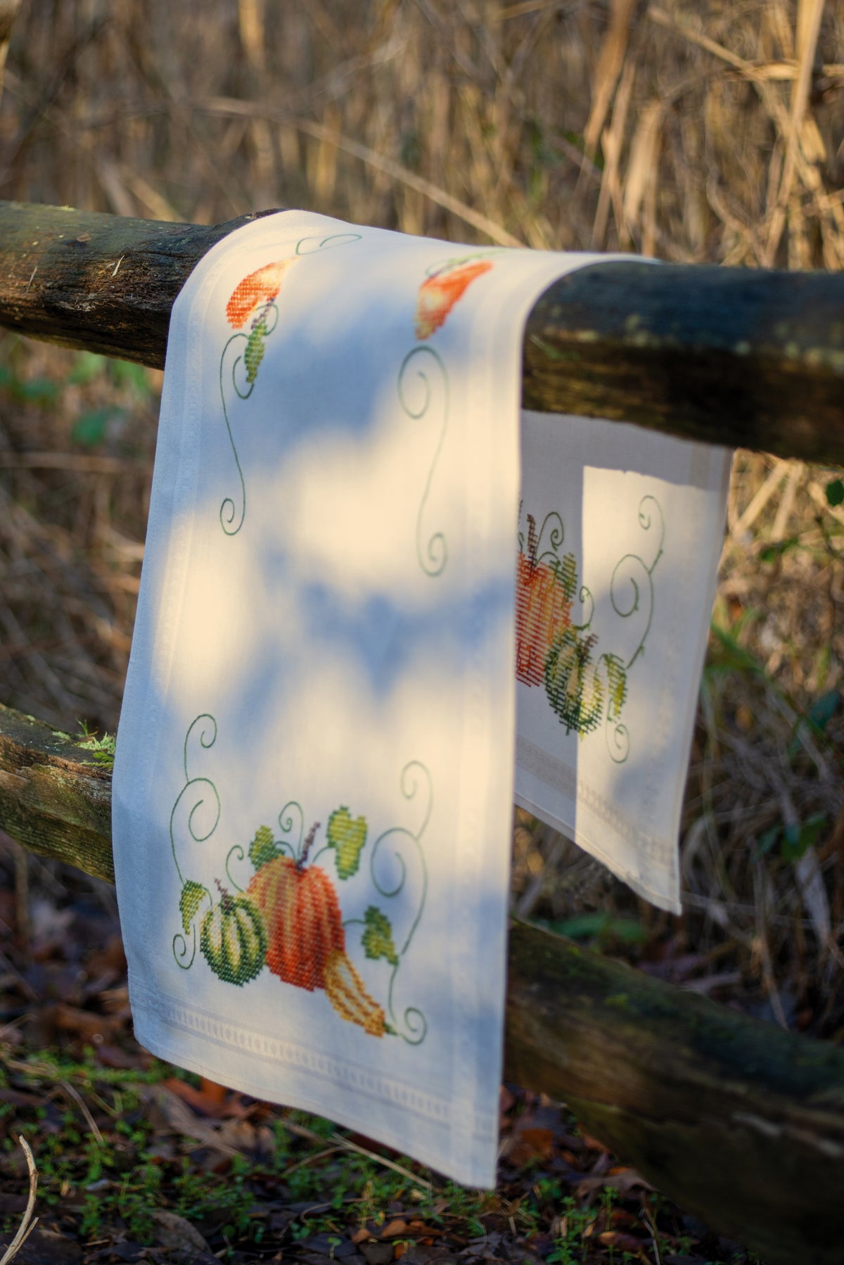 Ecru cotton table runner stitched with a pumpkins design