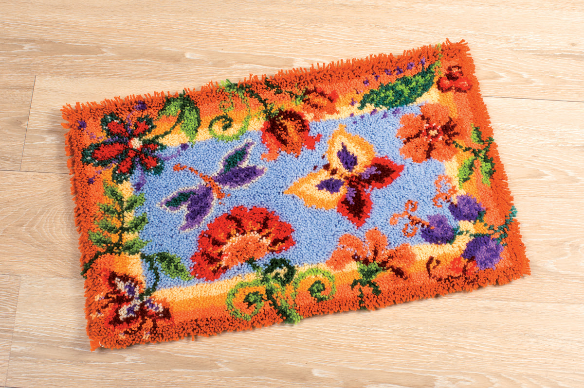 Latch hook rug showing a colourful flowers and butterflies design