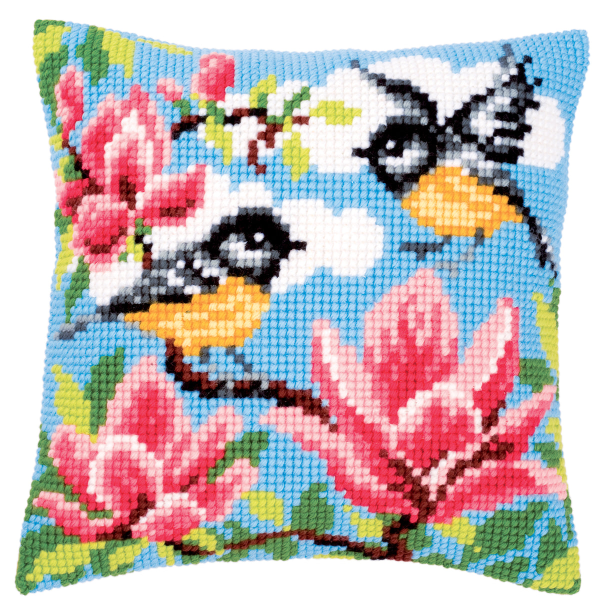 Cross stitch cushion front showing a pair of blue tits among pink magnolia flowers on a sky blue background