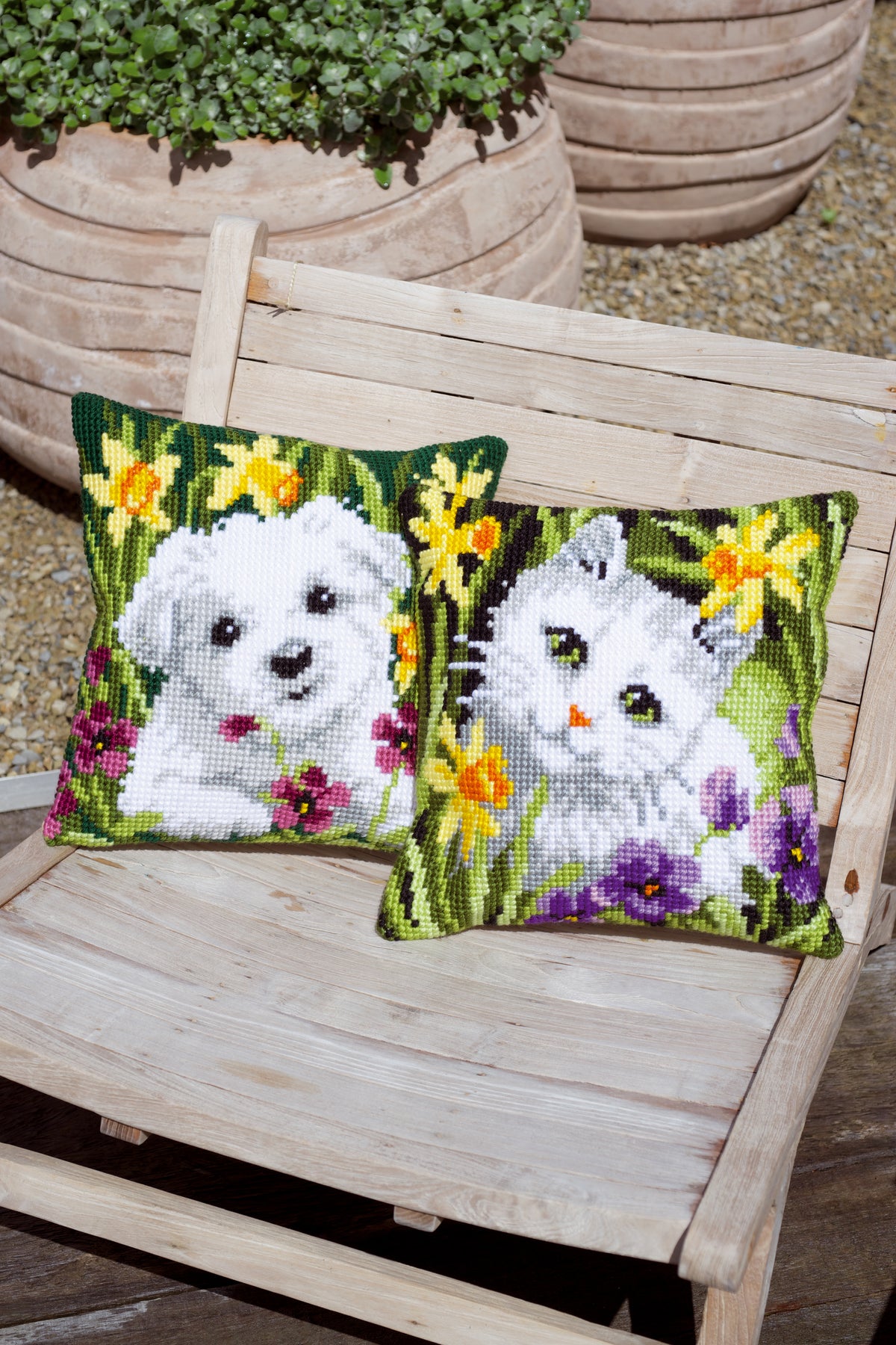Cross stitch cushion with a white cat among daffodils
