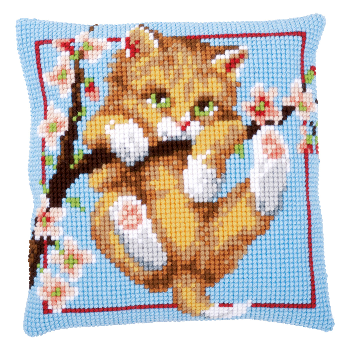 Cross stitch cushion with a ginger kitten hanging from a blossom branch on a pale blue background