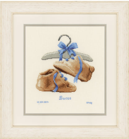 Counted cross stitch kit showing a pair of baby's first shoes
