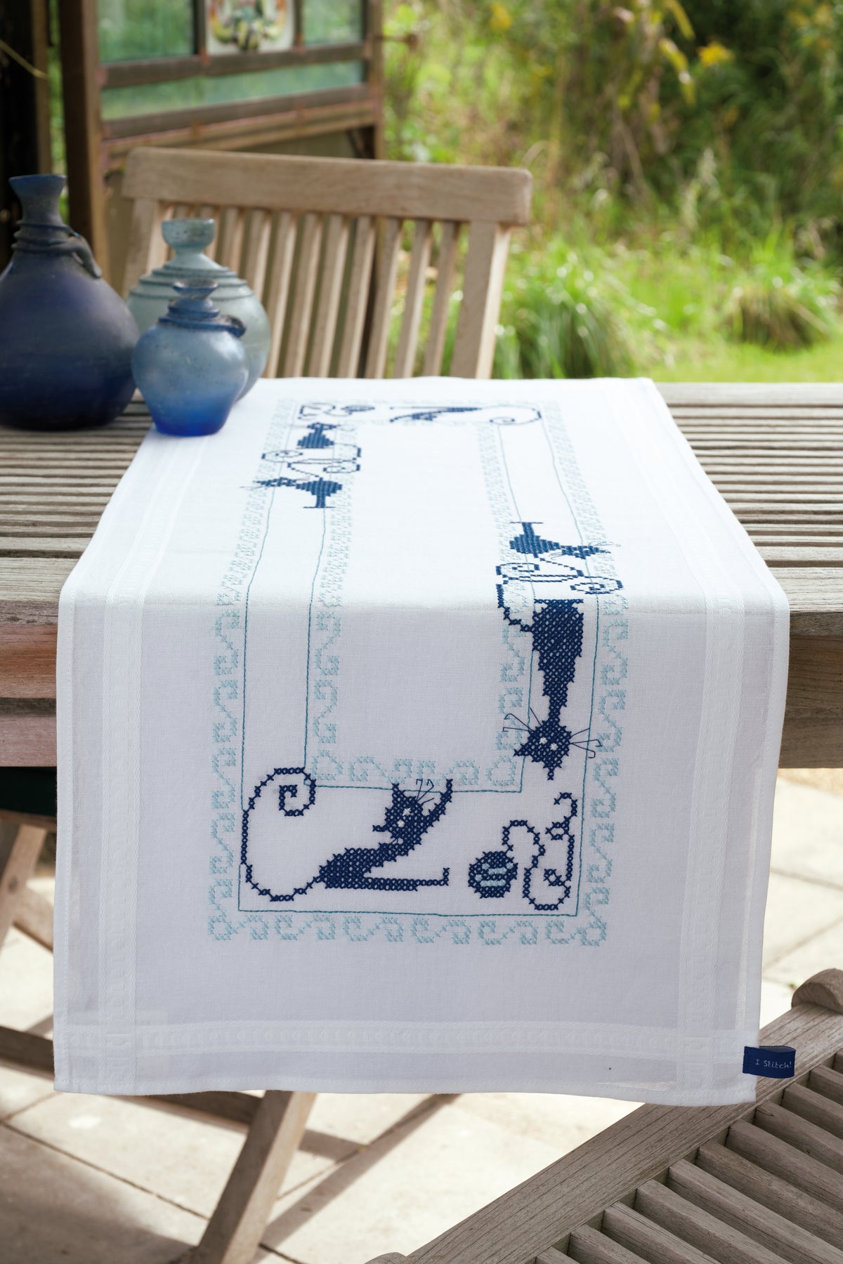 Embroidered white table runner with cat designs