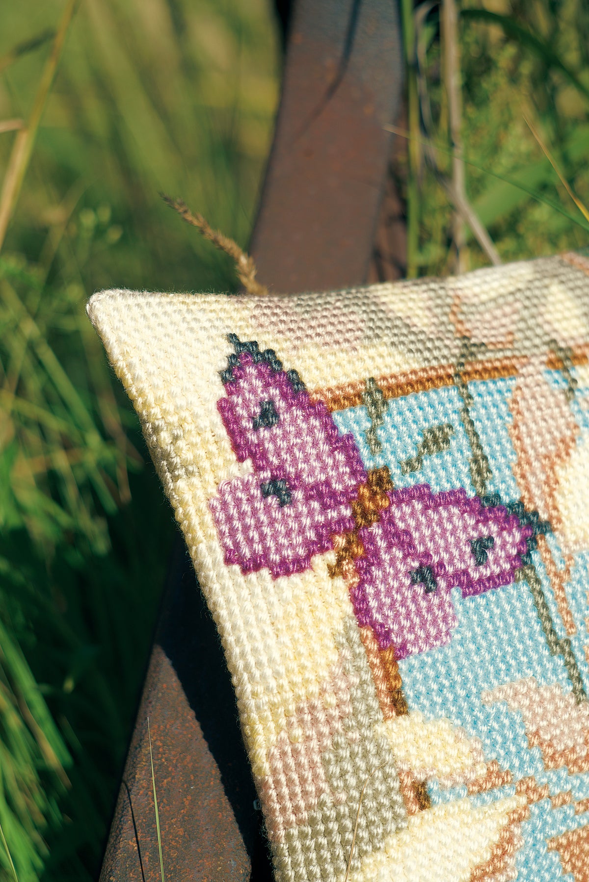 Cross stitch cushion with decorative butterflies