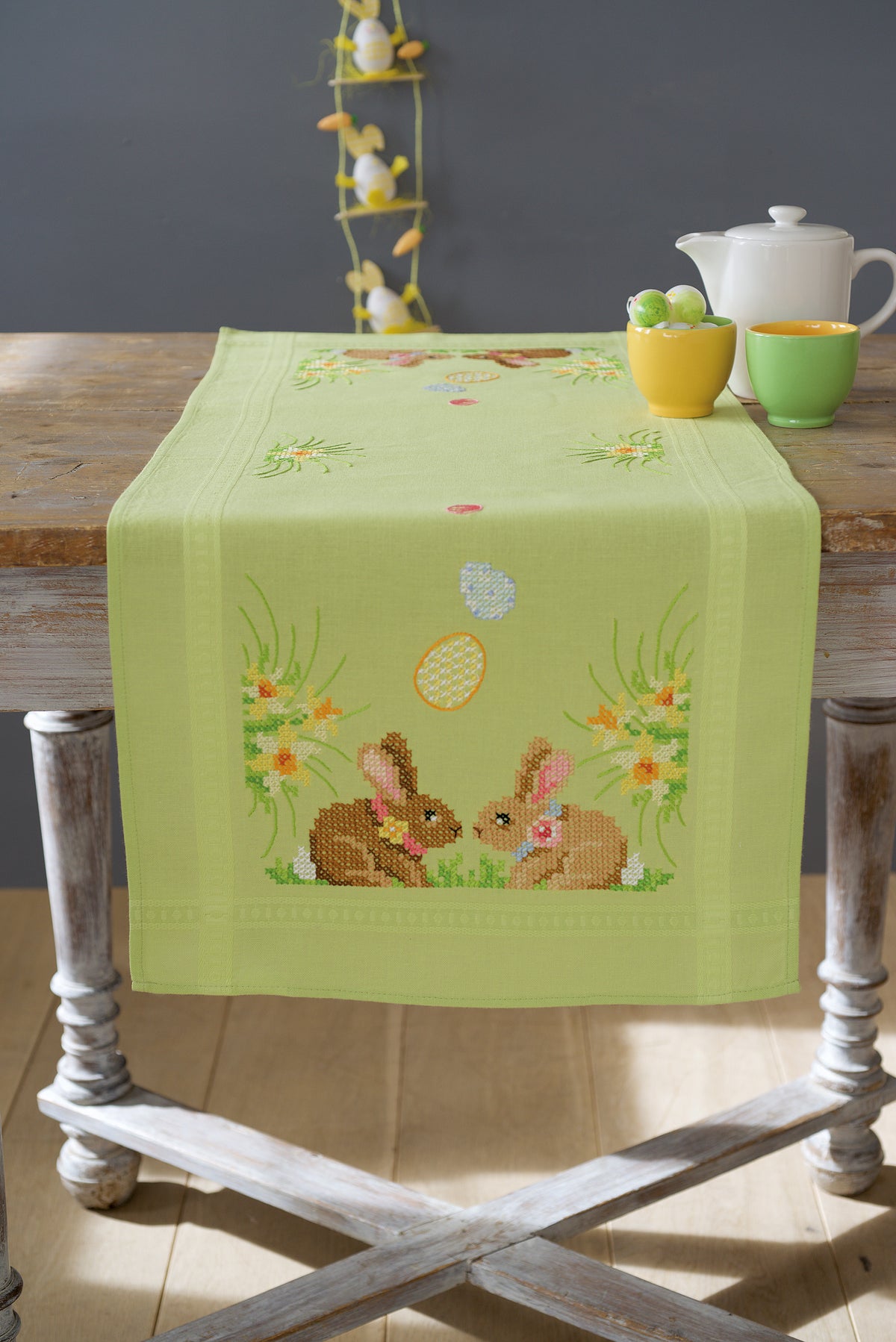 Embroidered table runner with Easter bunnies on green fabric