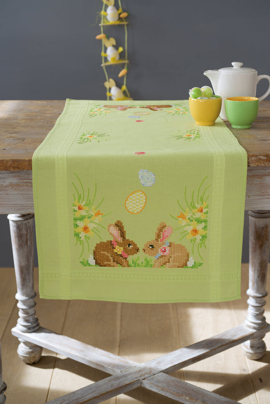 Embroidered table runner with Easter bunnies on green fabric