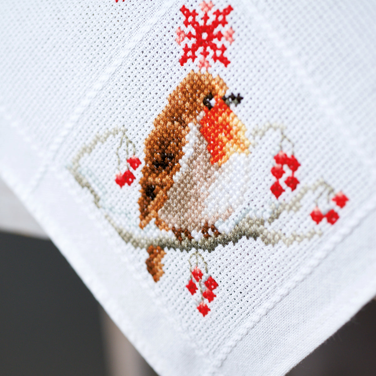 Cross stitched white tablecloth with robin design