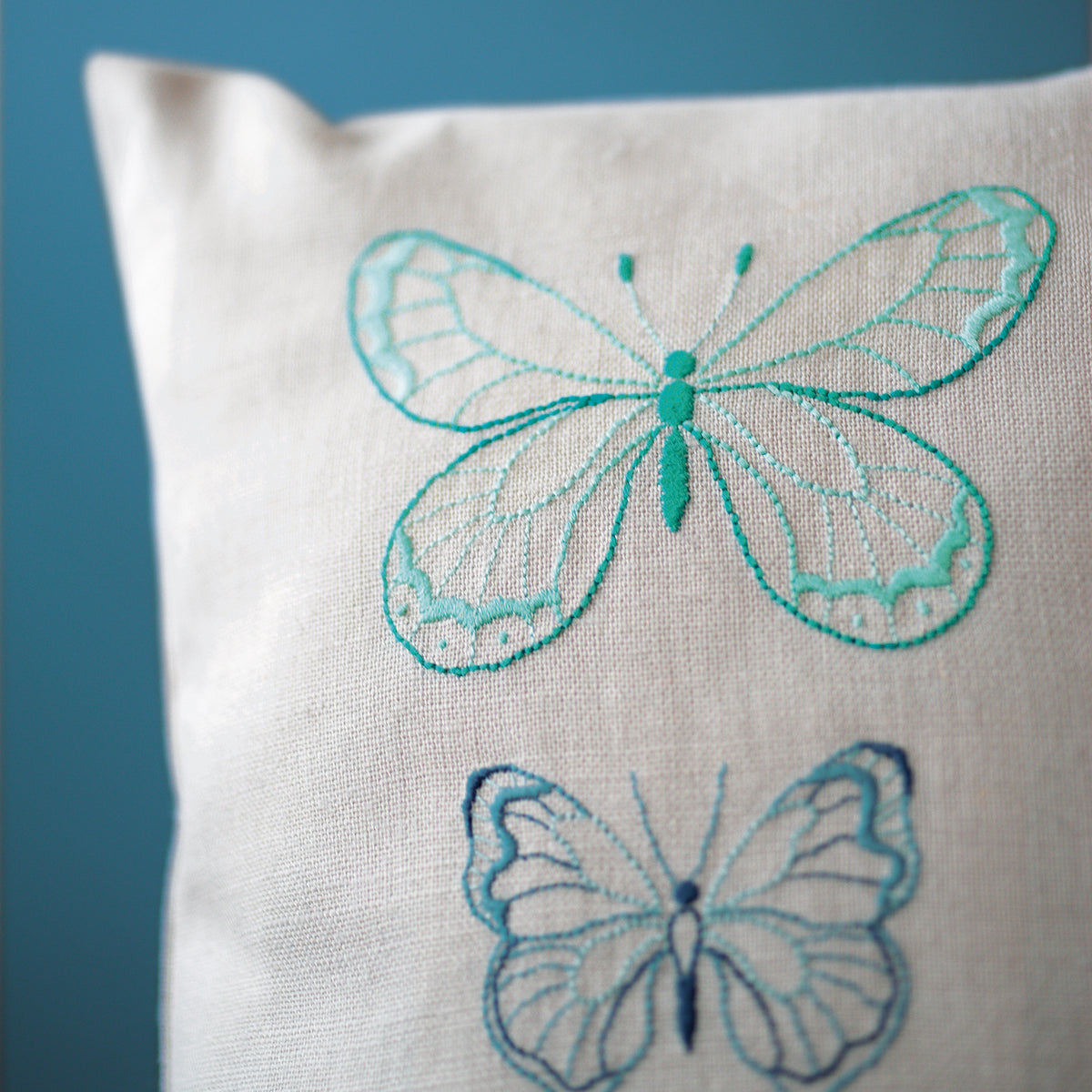 Grey cushion embroidered with blue butterflies