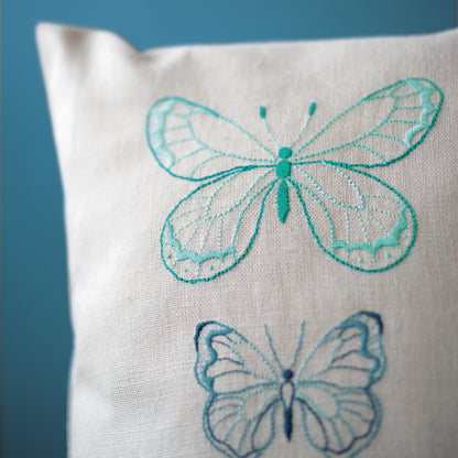 Grey cushion embroidered with blue butterflies
