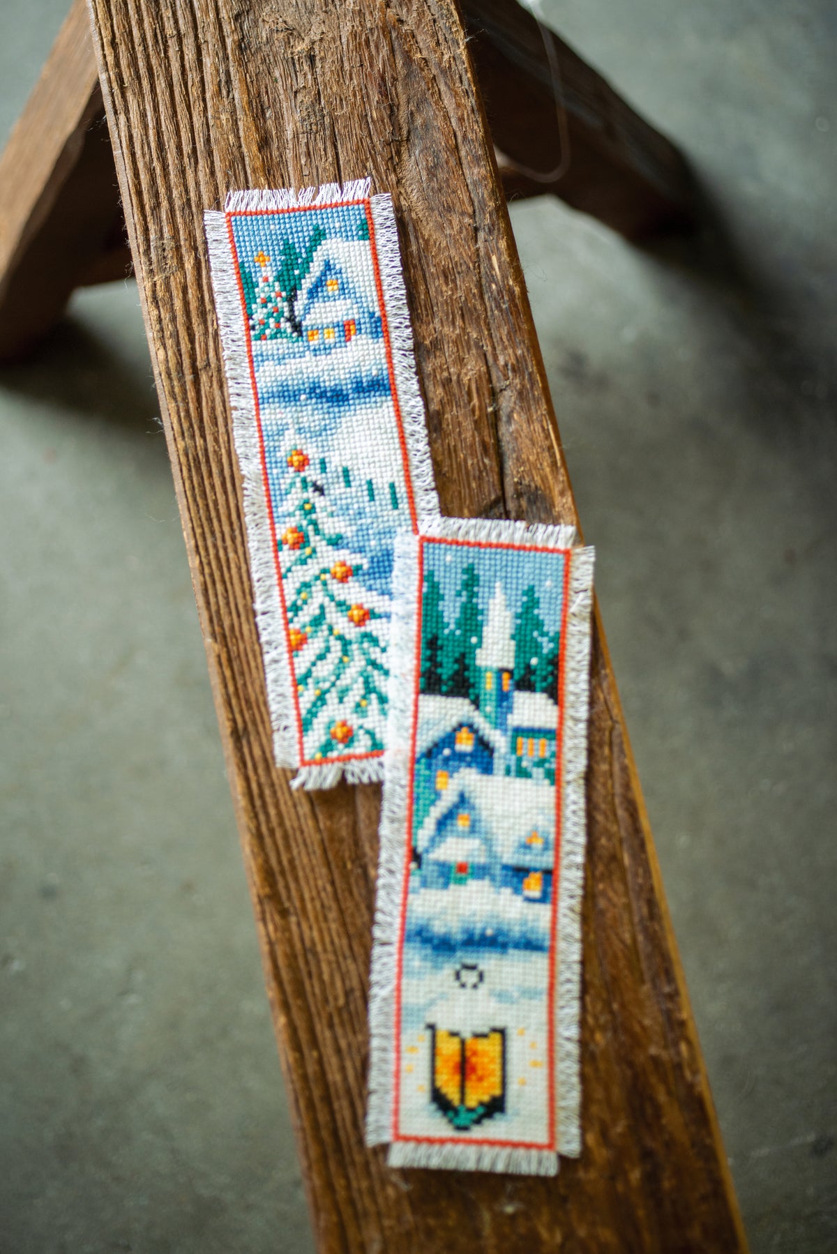 Two cross stitch bookmarks with winter village designs