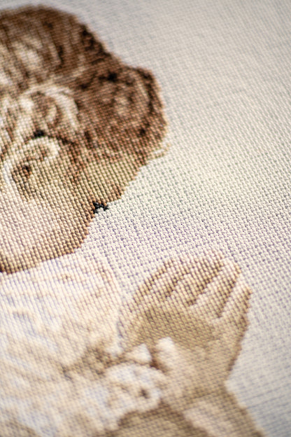 Cross stitch picture of a praying girl