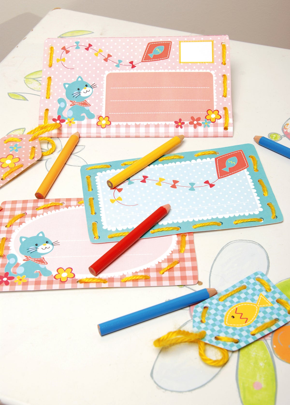 Children's stitched invitation cards and tags with a kitten design