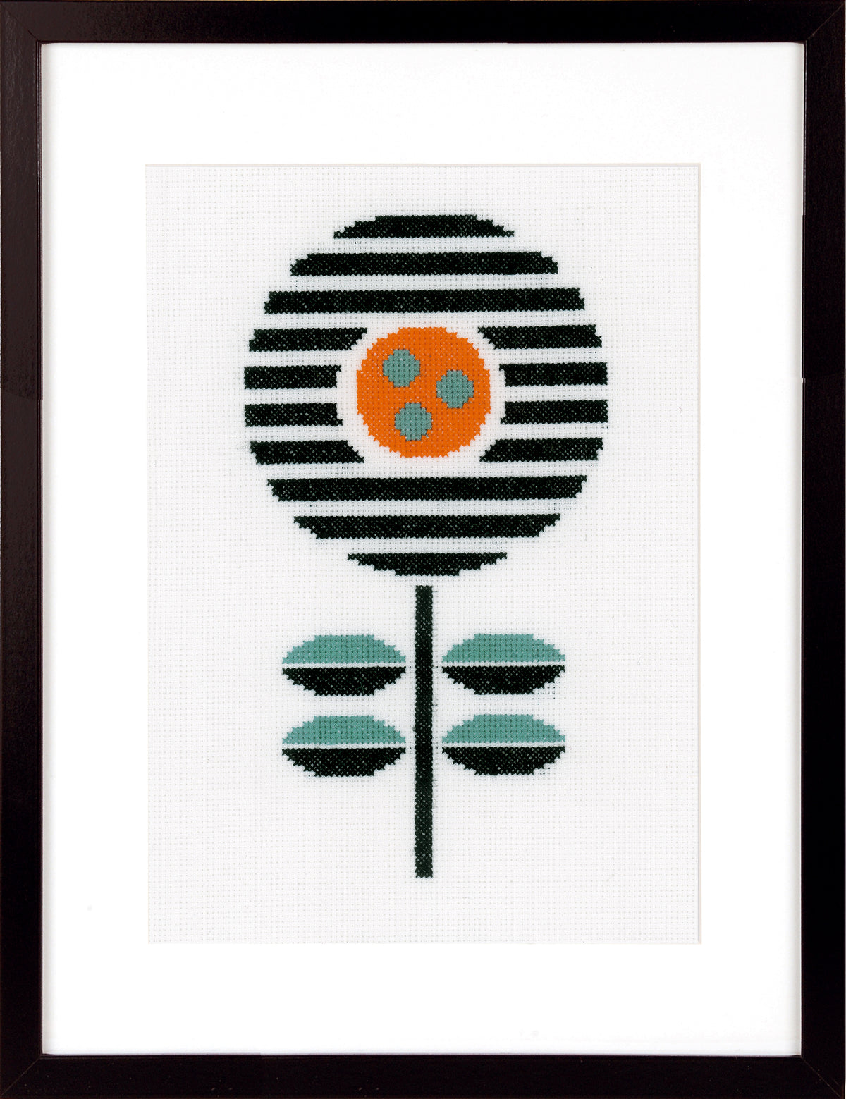 Framed cross stitch of a striped black flower with orange centre and teal leaves