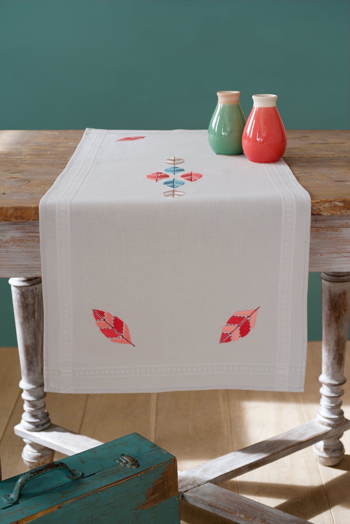 Embroidered pale grey table runner with feather designs