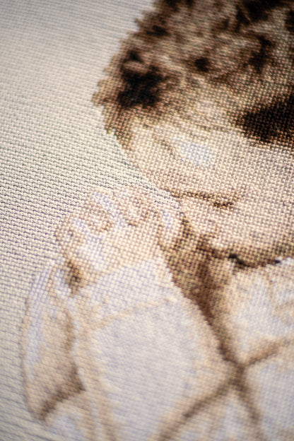 Framed cross stitch of a boy praying