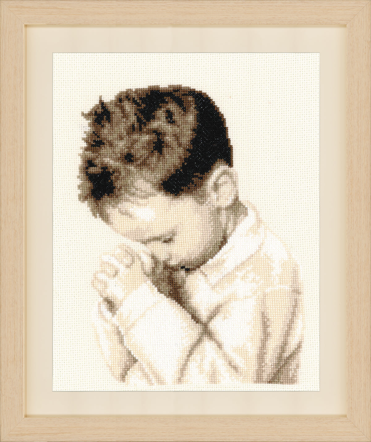 Framed cross stitch of a boy praying