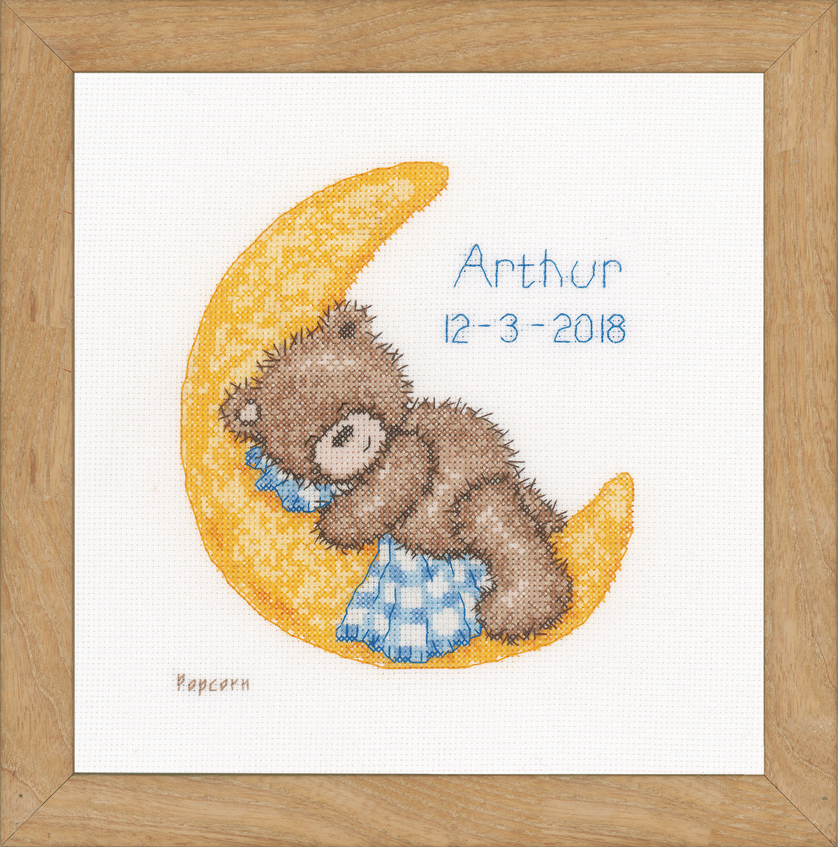 Cross stitch birth sampler with a sleeping bear
