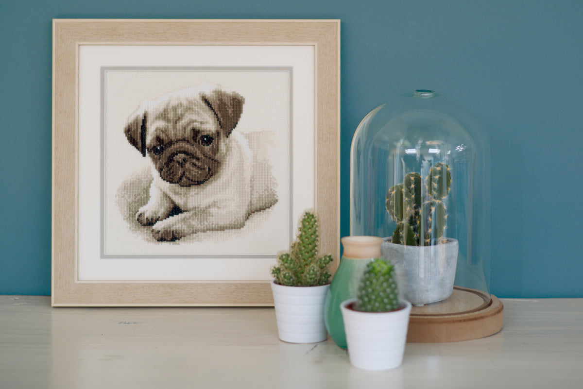 Cross stitched portrait of a pug dog