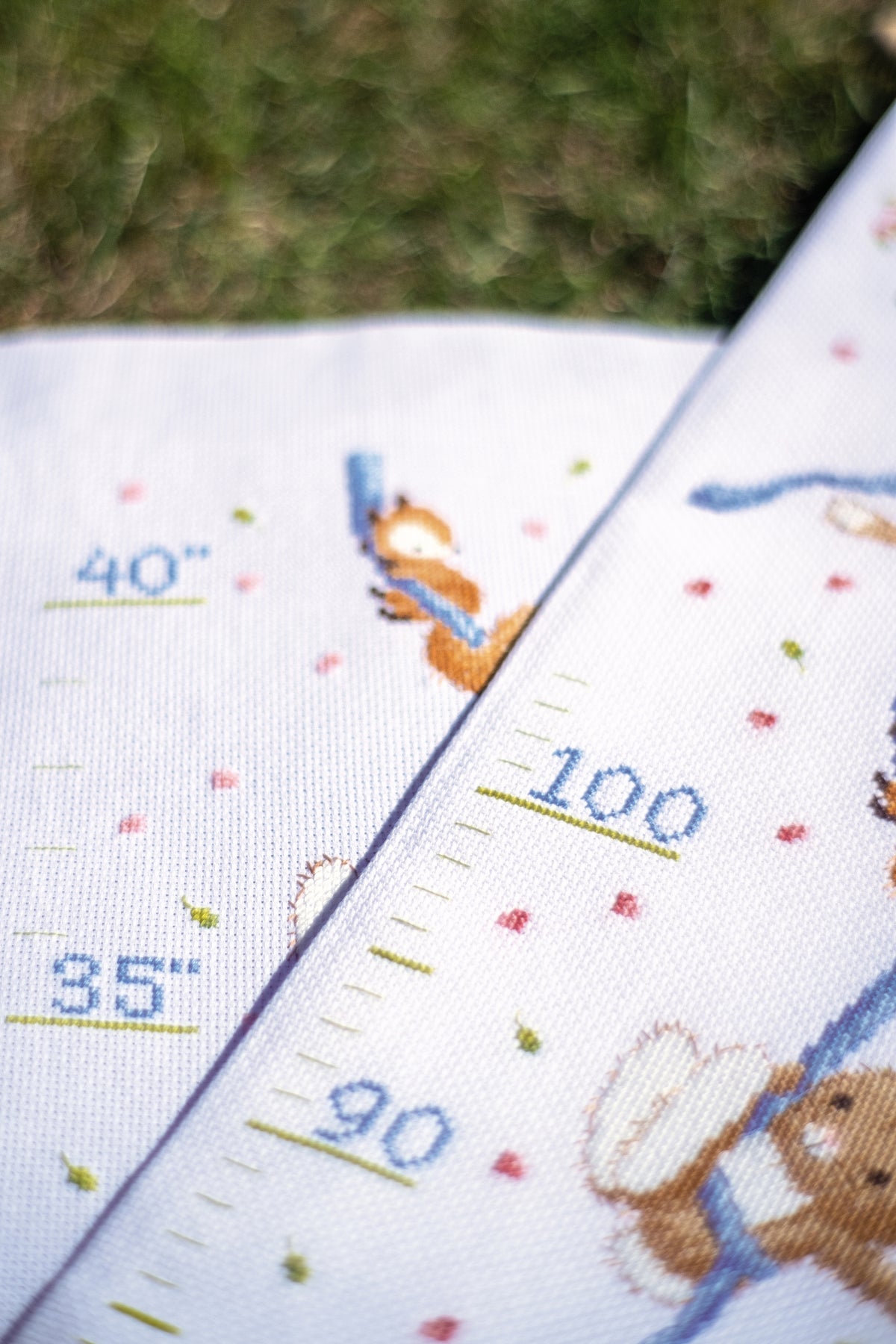 Cross stitched height chart with woodland animals