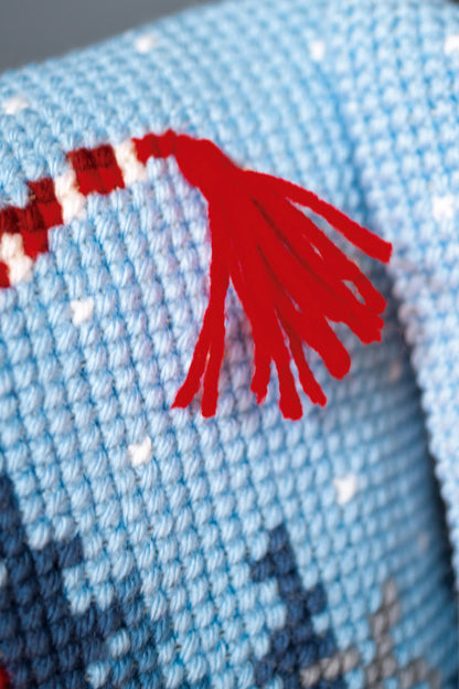 Cross stitch cushion with a skiing Christmas gnome