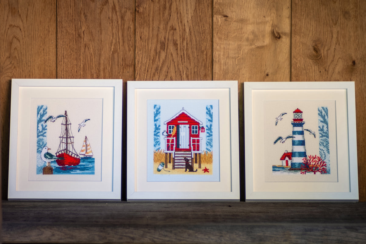 Cross stitch of a beach cabin on blue fabric