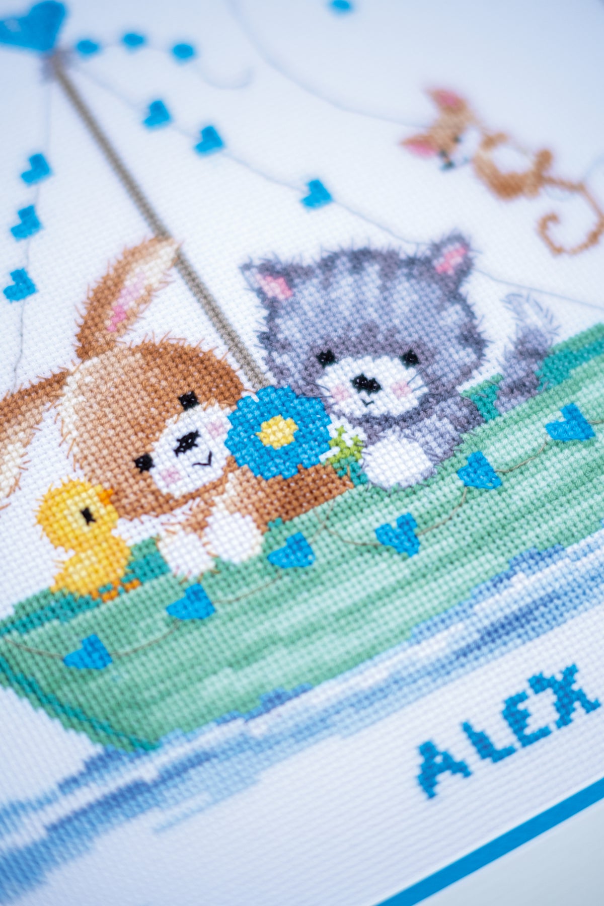 Cross stitched birth record reading Our Greatest Adventure