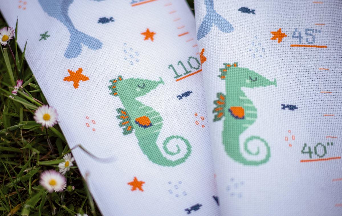 Cross stitched children's height chart with whales