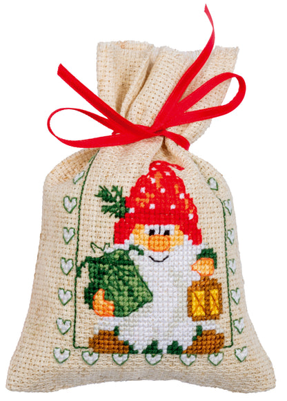 Three cross stitched Christmas gift bags tied with ribbon