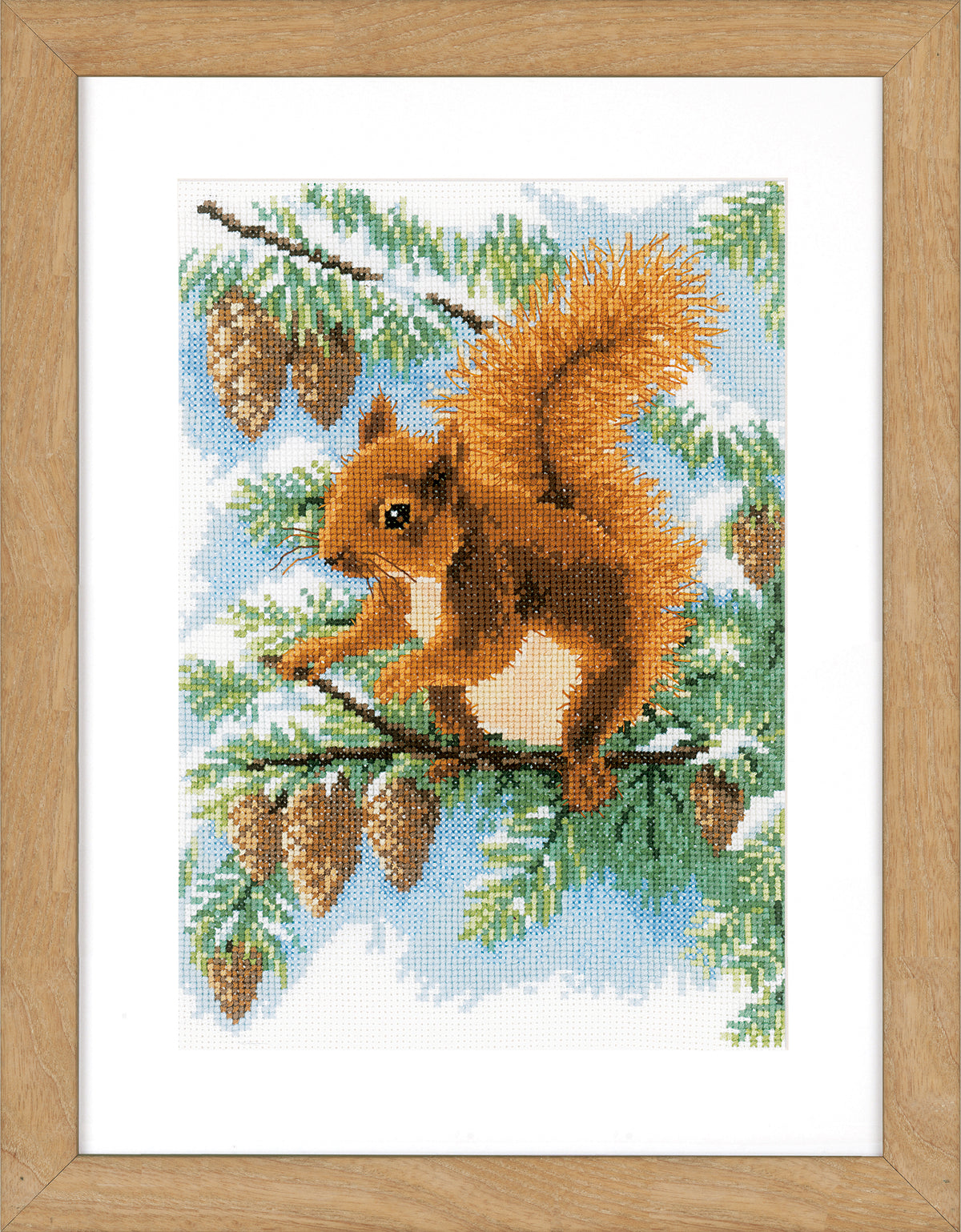 Cross stitch picture of a squirrel in a pine tree