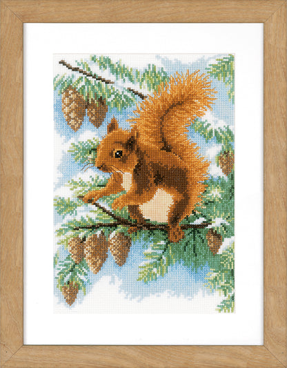 Cross stitch picture of a squirrel in a pine tree