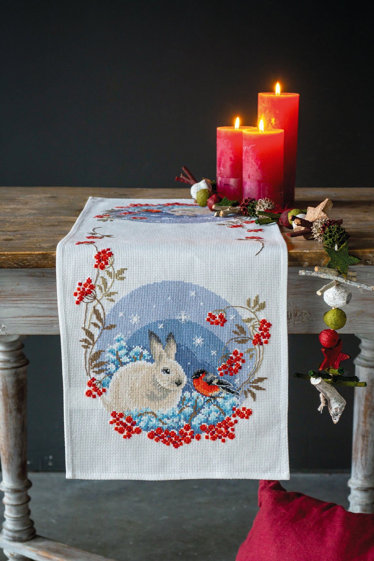 Cross stitch table runner with snow hare and goldfinches