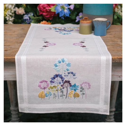 White table runner embroidered with blue and purple allium flowers