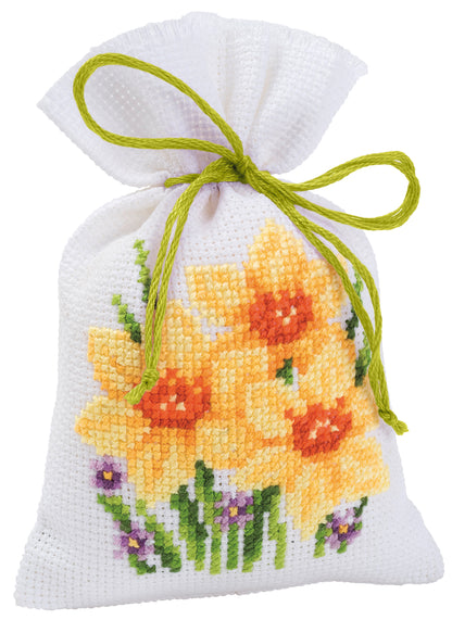 Three small white gift bags cross stitched with flowers