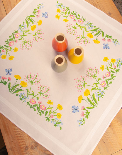 White tablecloth embroidered with colourful field flowers