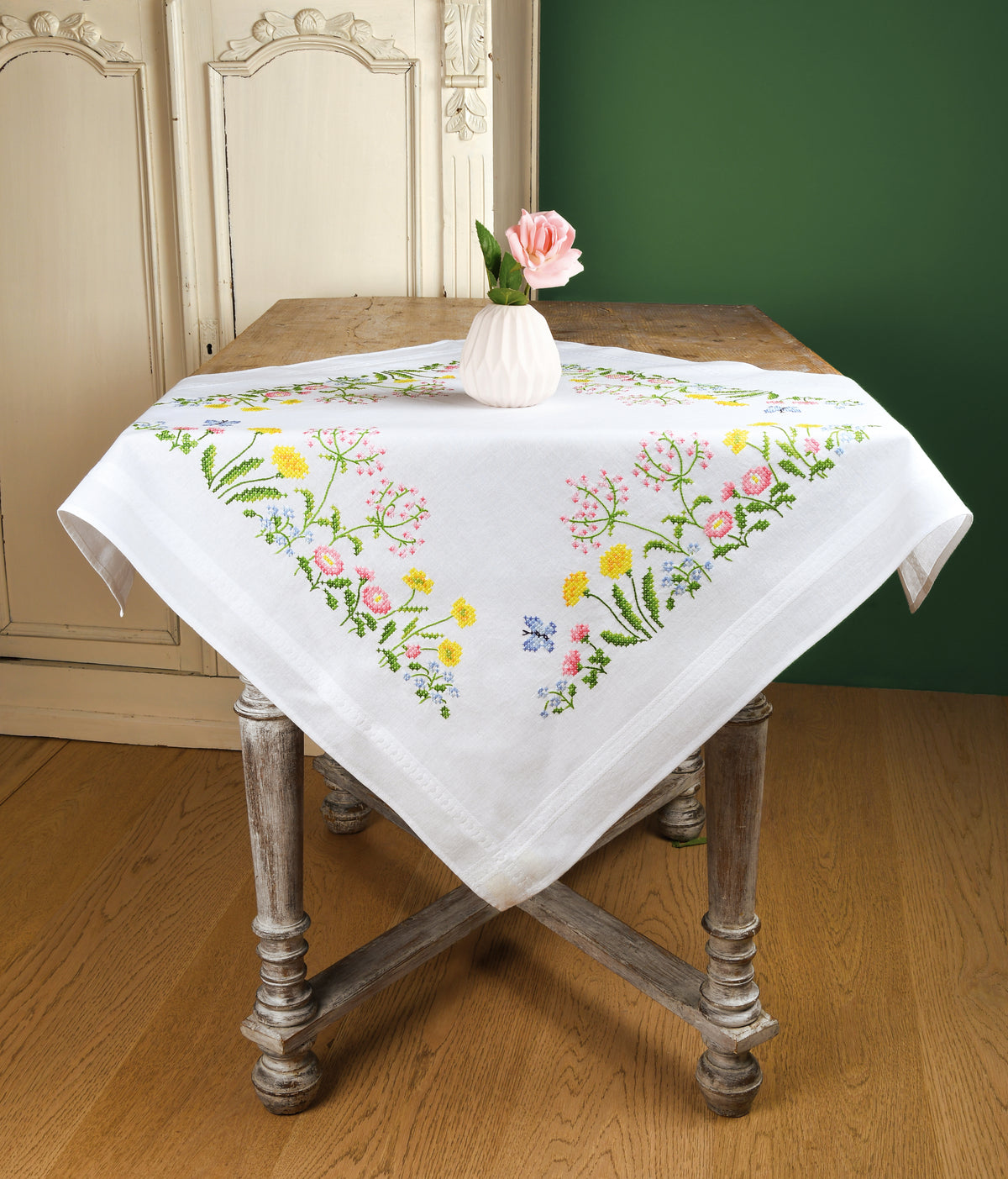 White tablecloth embroidered with colourful field flowers