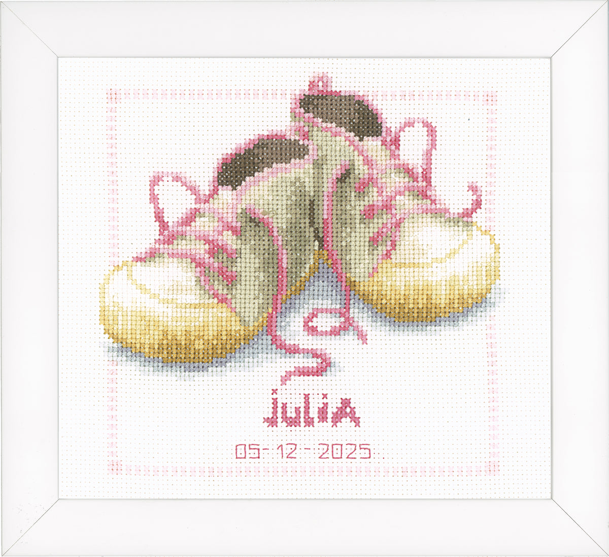 Cross stitched birth record with a pair of baby shoes