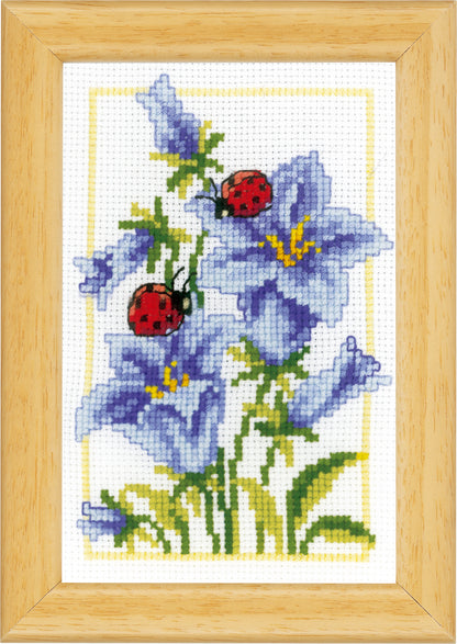 Three small cross stitched designs of flowers and ladybirds