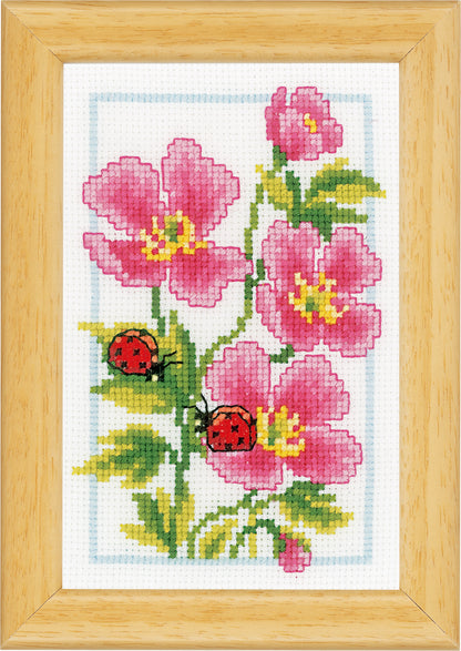 Three small cross stitched designs of flowers and ladybirds