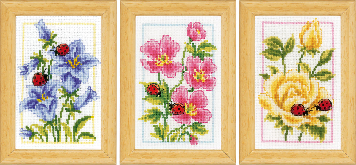 Three small cross stitched designs of flowers and ladybirds