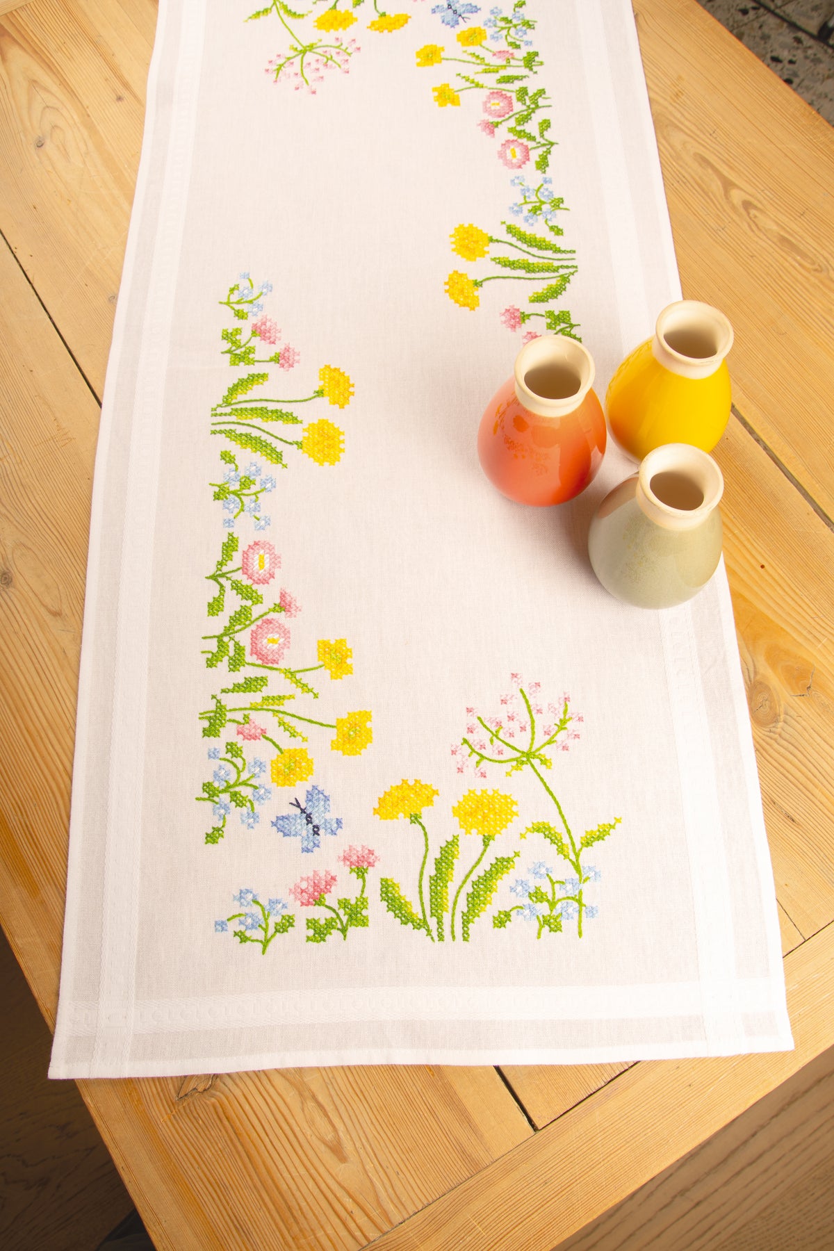 White table runner embroidered with colourful field flowers