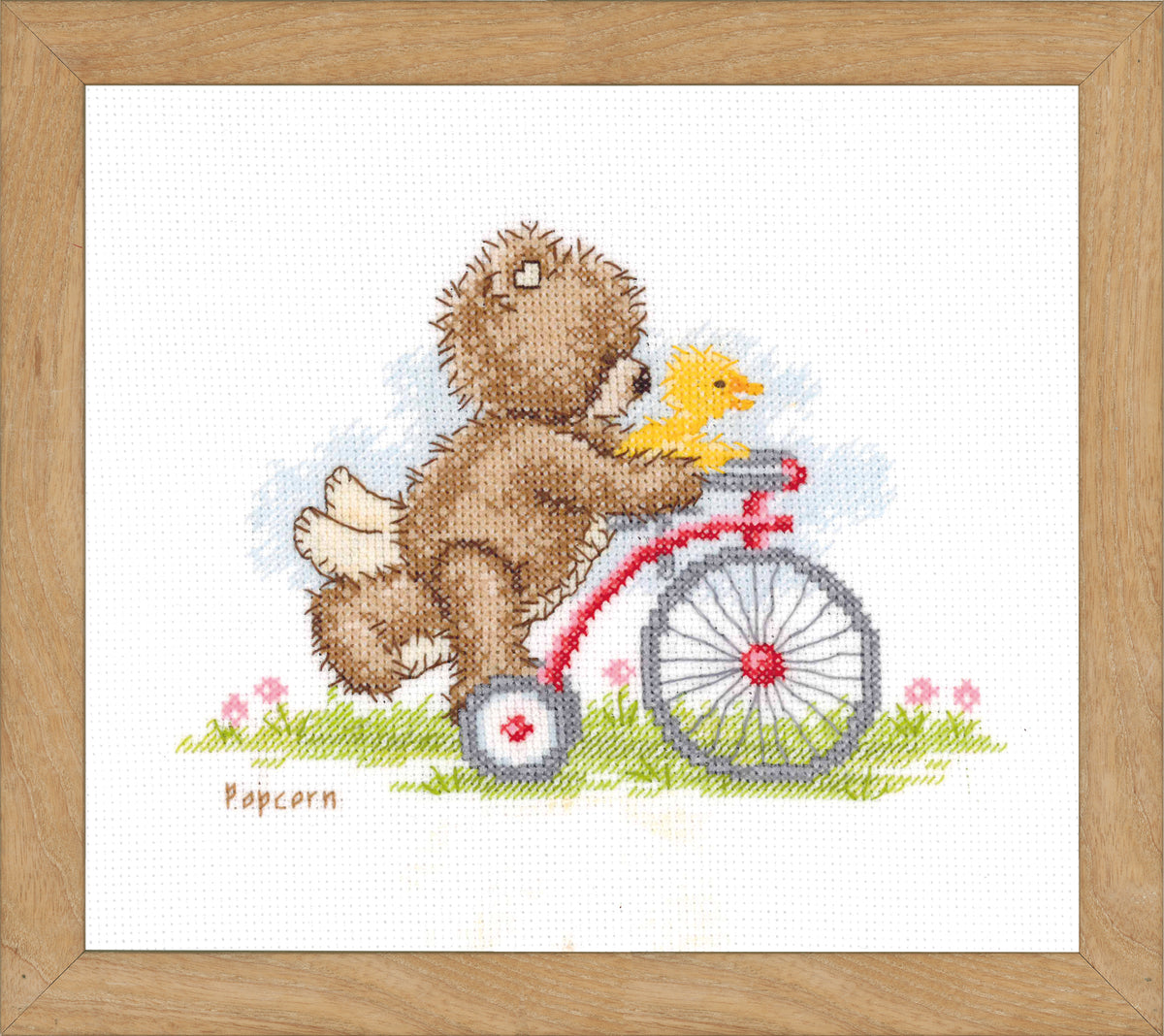 Popcorn bear riding a bicycle cross stitch design